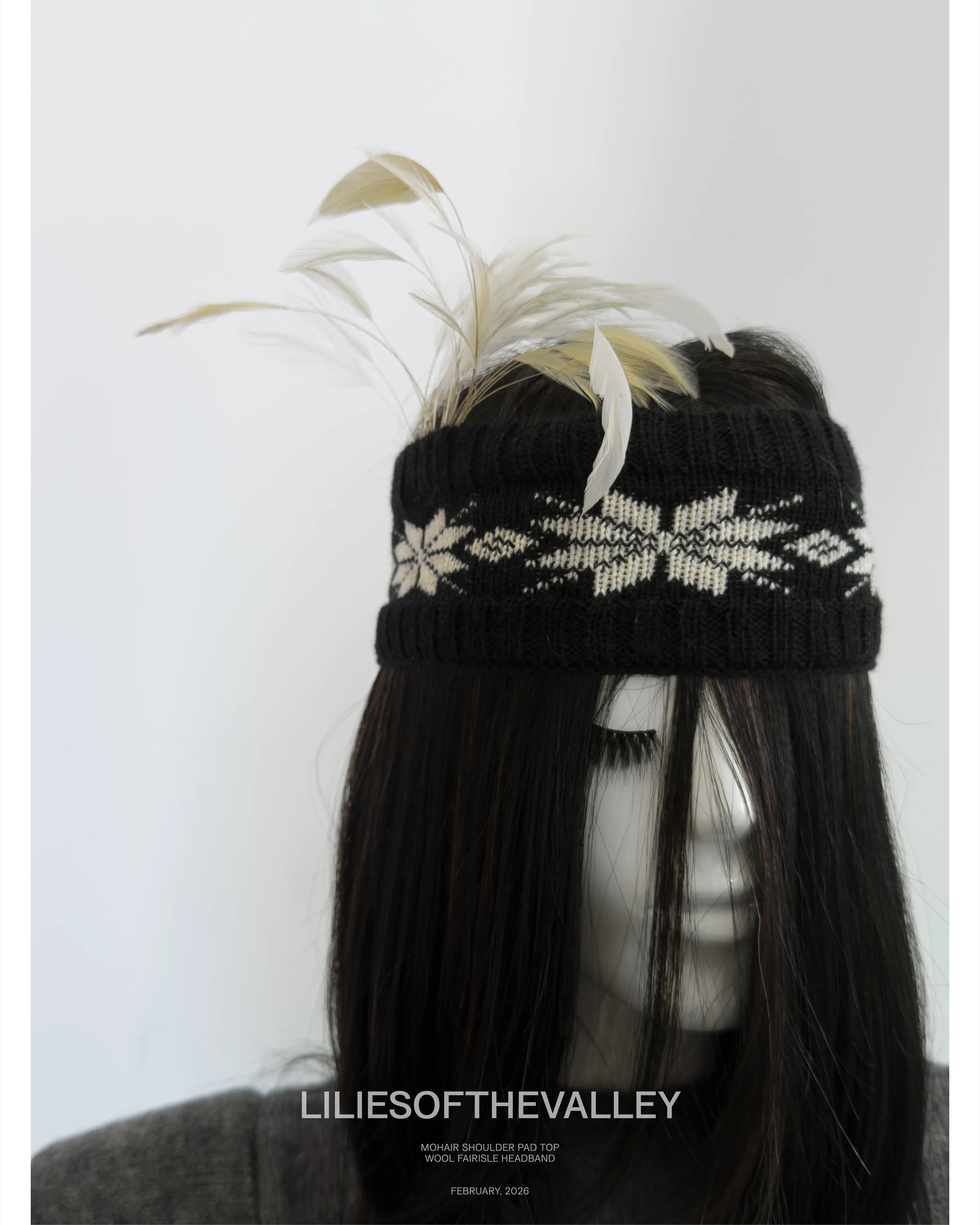 Campaign frame: close crop of the black and cream Fair Isle headband,
                    trimmed with feathers.
